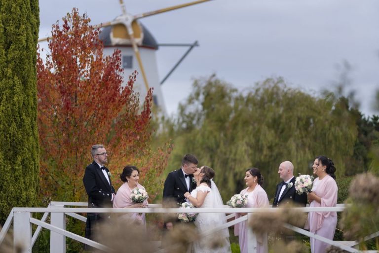 bridal party with windmill in the background